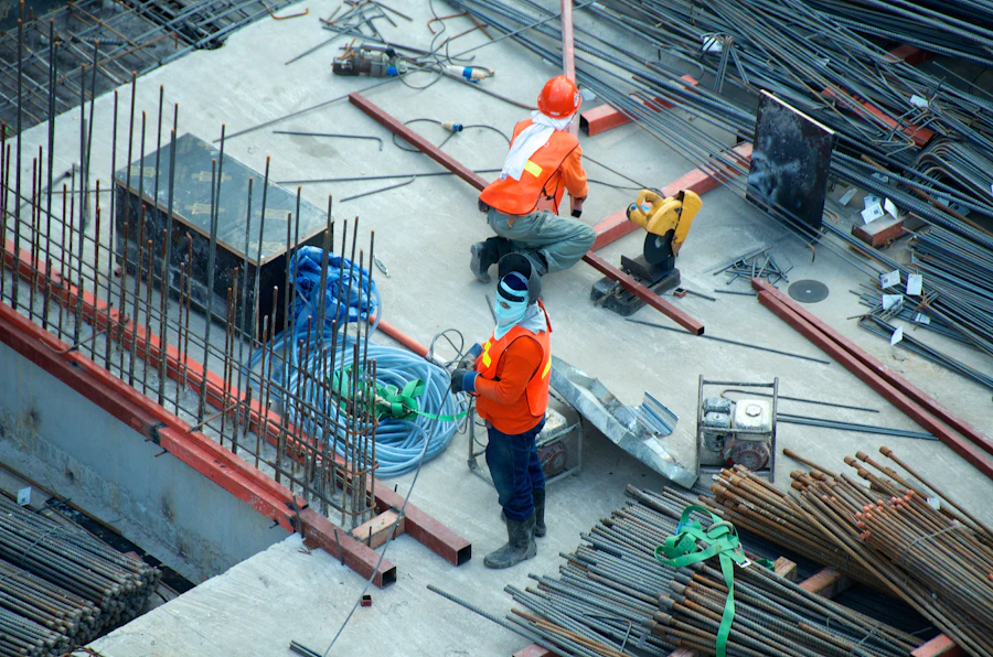 Chef de chantier et responsable serrant la main autour des plans sur un chantier en France